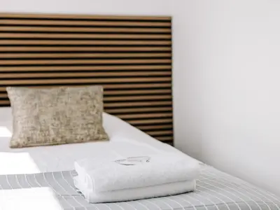 a white towel on a bed with a pillow at Bella Cottage Zandvoort in Zandvoort