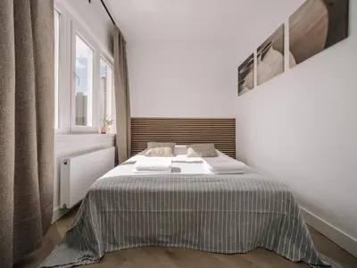 a bed in a white room with a window at Bella Cottage Zandvoort in Zandvoort