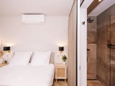 a bedroom with a white bed and a shower at Ceebee - Free parking in Zandvoort