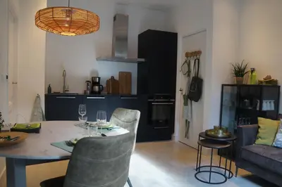 a living room with a table and chairs and a kitchen at natural green loft in Bergen