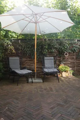 two chairs sitting under an umbrella on a patio at natural green loft in Bergen