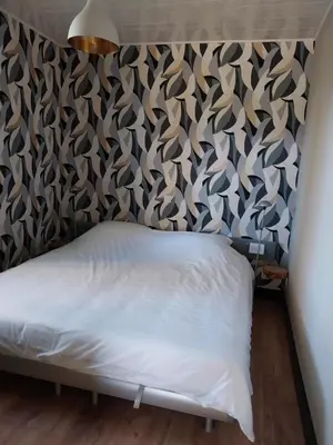 a bedroom with a bed and a wall covered in a wallpaper at Vakantiewoning Hem in Hem