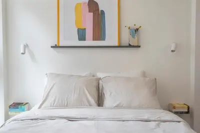 a bed with two pillows and a picture on the wall at Studio Carlos in Haarlem