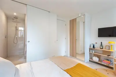a bedroom with a bed and a tv on a wall at Studio Carlos in Haarlem