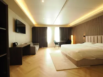 a hotel room with a bed and a couch and a desk at Tung Hotel in Zeewolde