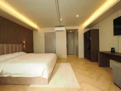 a bedroom with a white bed and a television at Tung Hotel in Zeewolde