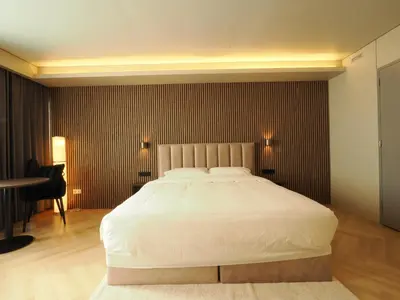 a bedroom with a large bed and a desk at Tung Hotel in Zeewolde
