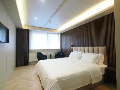 a bedroom with a large white bed and a window at Tung Hotel in Zeewolde