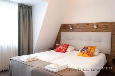 a bedroom with two beds with towels on them at Dijkstra Hotels in Bergen
