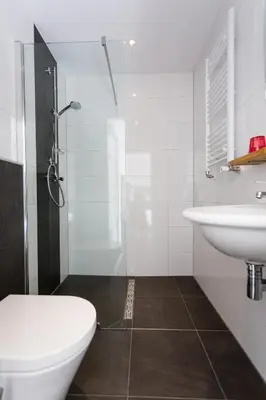 a white bathroom with a toilet and a sink at Dijkstra Hotels in Bergen