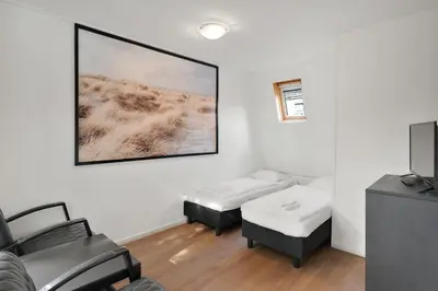 a room with two beds and a flat screen tv at Dijkstra Hotels in Bergen