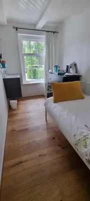 a bedroom with a bed and a desk and a window at Beautiful renovated Farmhouse in Ankeveen