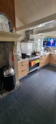 a large kitchen with a stove and a fireplace at Beautiful renovated Farmhouse in Ankeveen