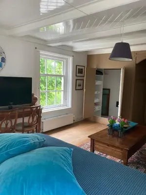 a bedroom with a bed and a table with flowers on it at Beautiful renovated Farmhouse in Ankeveen