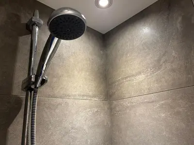 a shower in a bathroom with a shower head at Cozy room just outside Utrecht Center, calm & green in Utrecht