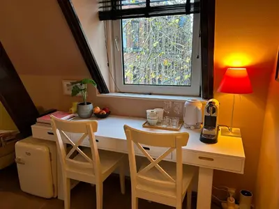 a kitchen with a desk with two chairs and a window at Cozy room just outside Utrecht Center, calm & green in Utrecht
