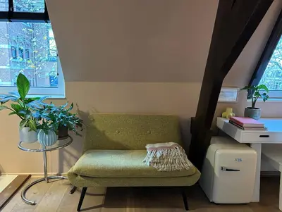 a living room with a green chair and a table at Cozy room just outside Utrecht Center, calm & green in Utrecht