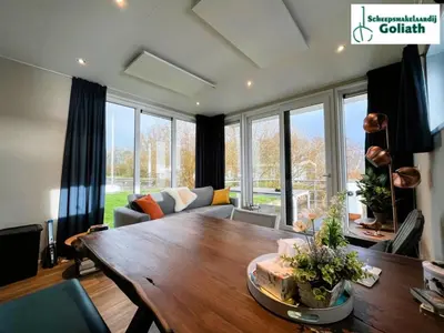 a living room with a table and a couch at Houseboat Tjonger NS003 in Monnickendam