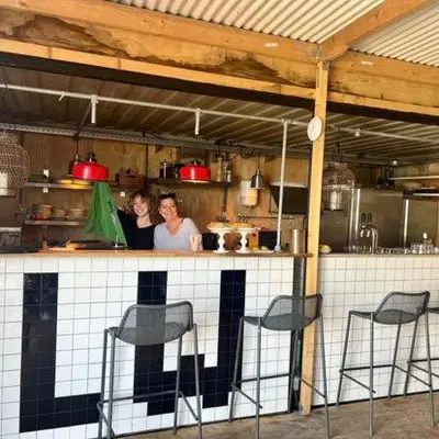 two people standing at a counter in a kitchen at Houseboat Tjonger NS003 in Monnickendam