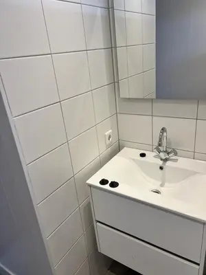 a white bathroom with a sink and a mirror at Huisje Aangenaam in Dirkshorn