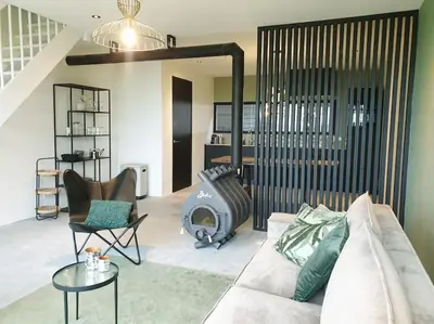 a living room with a couch and a fireplace at Luxe stal appartement in Loenen aan de Vecht