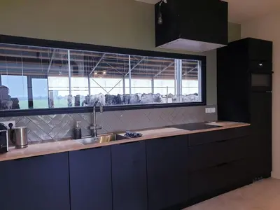 a kitchen with a sink and a large window at Luxe stal appartement in Loenen aan de Vecht