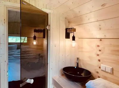a bathroom with a sink and a glass shower at Twee heerlijke Boomhutten in de natuur, Amsterdam in Nigtevecht