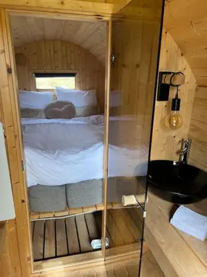 a small room with a bed in a wooden cabin at Twee heerlijke Boomhutten in de natuur, Amsterdam in Nigtevecht