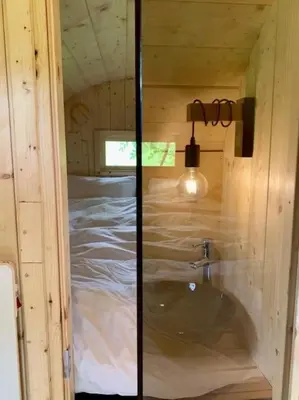 a bathroom with a sink in a wooden house at Twee heerlijke Boomhutten in de natuur, Amsterdam in Nigtevecht