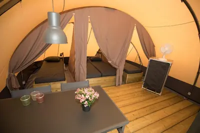 a room with a table and a tent at Glamping at the water, close to Amsterdam in Aalsmeer