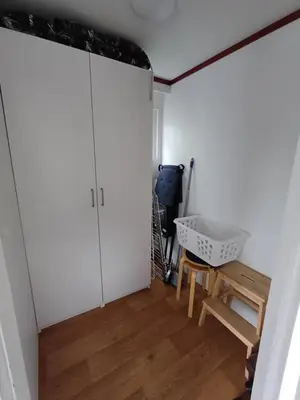 a room with a white closet and a wooden table at Chalet dichtbij zee en duinen in Heemskerk
