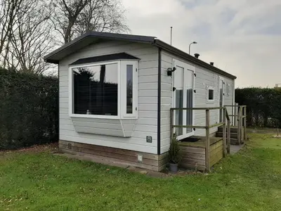 a tiny house with a window and a staircase at Chalet dichtbij zee en duinen in Heemskerk
