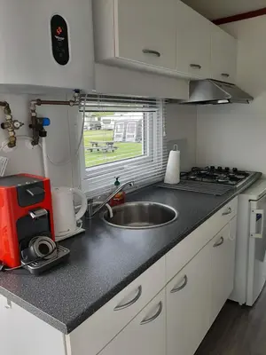 a kitchen with a sink and a counter top at Chalet dichtbij zee en duinen in Heemskerk