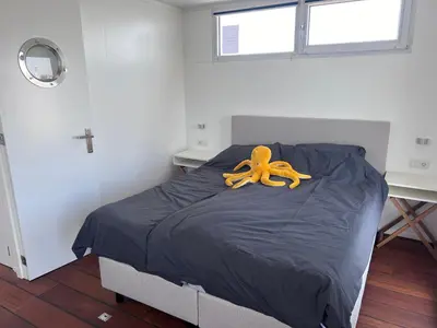 a bed with a large orange ribbon on it at Oktopus-Lofts - Houseboat in Lelystad