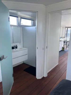 a white bathroom with a sink and a mirror at Oktopus-Lofts - Houseboat in Lelystad