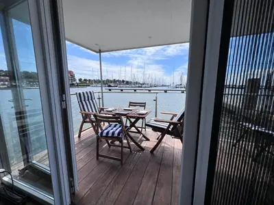 a balcony with a table and chairs on a boat at Oktopus-Lofts - Houseboat in Lelystad