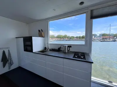a kitchen with a sink and a large window at Oktopus-Lofts - Houseboat in Lelystad