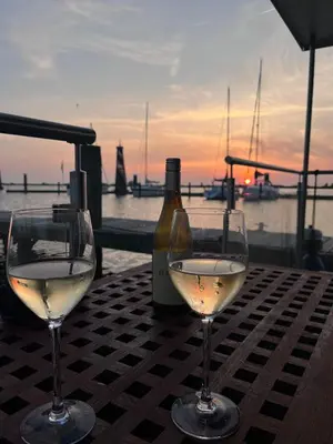 two wine glasses sitting on a table with a bottle of wine at Oktopus-Lofts - Houseboat in Lelystad