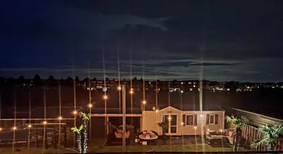 a house with lights on the roof at night at Chalet aan zee in Noordwijk aan Zee