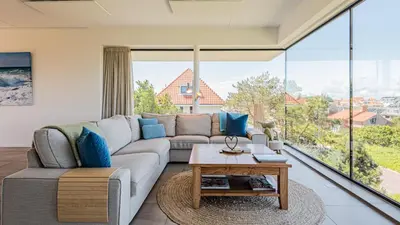 a living room with a couch and a table at Villa Sea breeze in Bergen aan Zee