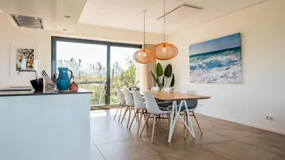 a kitchen and dining room with a table and chairs at Villa Sea breeze in Bergen aan Zee