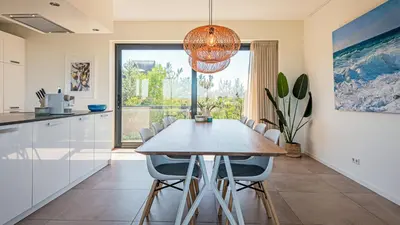 a kitchen and dining room with a table and chairs at Villa Sea breeze in Bergen aan Zee