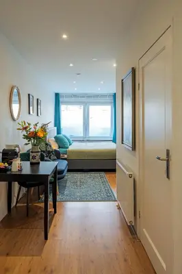 a living room with a couch and a table at Suite with private bathroom near Vondelpark in Amsterdam