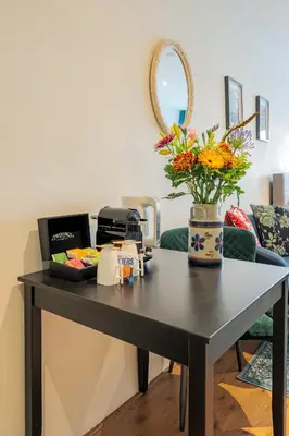 a table with flowers on it in a living room at Suite with private bathroom near Vondelpark in Amsterdam