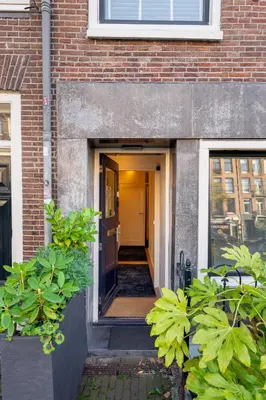an open door of a brick building with plants at Suite with private bathroom near Vondelpark in Amsterdam