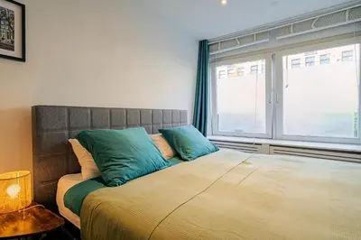 a bedroom with a large bed with blue pillows at Suite with private bathroom near Vondelpark in Amsterdam