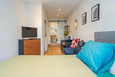 a bedroom with a bed and a tv and a couch at Suite with private bathroom near Vondelpark in Amsterdam