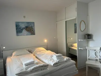 a bedroom with a bed with white sheets and pillows at Blue Fish in Zandvoort