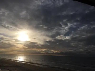 a cloudy sky over a beach with the ocean at Blue Fish in Zandvoort