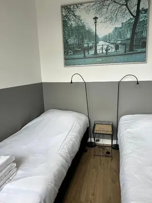 two beds in a room with a picture on the wall at De Schelp 86, Garden and Free parking in Zandvoort